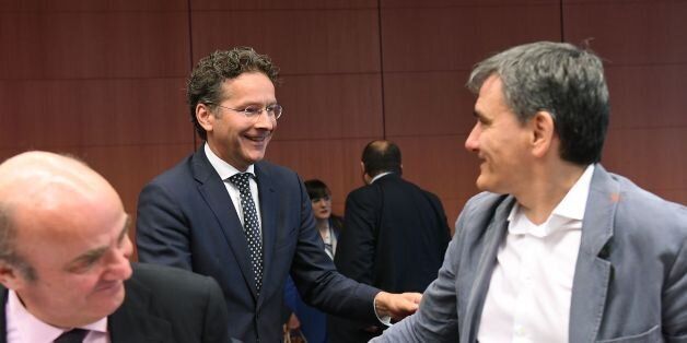 Eurogroup President and The Netherlands' Finance Minister Jeroen Dijsselbloem (C) shakes hands with Greece's Finance Minister Euclid Tsakalotos (R) as Spanish Finance Minister Luis de Guindos Jurado looks on during a Eurogroup finance ministers meeting on May 22, 2017 at the European Council in Brussels. / AFP PHOTO / EMMANUEL DUNAND (Photo credit should read EMMANUEL DUNAND/AFP/Getty Images)