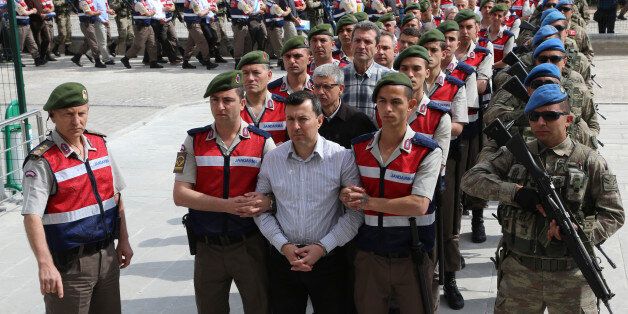 Arrested soldiers accused of being involved in an attempted coup d'etat on 15 July 2016 in Turkey, are accompanied by Turkish soldiers as they arrive at the court inside the Sincan Prison in Ankara, on May 22, 2017 to be trialed. The trial opened on May 22, 2017 of more than 220 suspects, including over two dozen former Turkish generals, accused of being among the ringleaders of the attempted coup last year aimed at ousting President Recep Tayyip Erdogan. / AFP PHOTO / ADEM ALTAN (Photo c