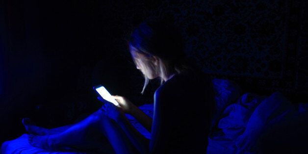 young women using the smart phone on bed before sleep