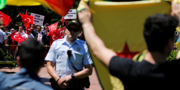 A group of pro-Erdogan demonstrators shout slogans at a group of anti-Erdogan Kurds (foreground, back to camera) in Lafayette Park as Turkey's President Tayyip Erdogan met with U.S. President Donald Trump nearby at the White House in Washington, U.S. May 16, 2017. REUTERS/Jonathan Ernst