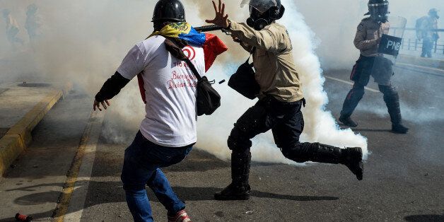 A riot policeman struggles with a demonstrator during a protest against the government of President Nicolas Maduro in Caracas on May 20, 2017. Venezuelan protesters and supporters of embattled President Nicolas Maduro take to the streets Saturday as a deadly political crisis plays out in a divided country on the verge of paralysis. / AFP PHOTO / FEDERICO PARRA (Photo credit should read FEDERICO PARRA/AFP/Getty Images)