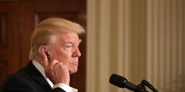 WASHINGTON, DC - MAY 18: U.S. President Donald Trump adjusts his ear bud during a joint news conference with Colombian President Juan Manuel Santos in the East Room of the White House May 18, 2017 in Washington, DC. The Trump administration has said it wants to slash foreign aide and Santos will most likely seek a renewal of $450 million dollars from the U.S. that supports the peace accord between the Columbian government at the Revolutionary Armed Forces (FARC). (Photo by Chip Somodevilla/Getty Images)
