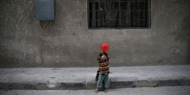 A child plays with a balloon in the rebel-held besieged city of Douma, in the eastern Damascus suburb of Ghouta, Syria November 13, 2016. REUTERS/Bassam Khabieh TPX IMAGES OF THE DAY