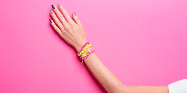 Single woman hand, wearing jewelry, in various background colors. Graphic look, solid bold colors, close up shot.