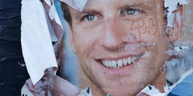A picture taken on May 9, 2017 shows a vandalised electoral campaign poster of French president-elect Emmanuel Macron in Paris. / AFP PHOTO / JOEL SAGET (Photo credit should read JOEL SAGET/AFP/Getty Images)