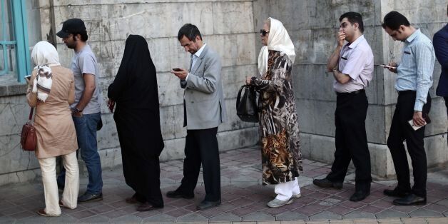 Iranians line up to cast their ballot at a polling station in Tehran on May 19, 2017.Iranians head to the polls for a vote that has become a referendum on President Hassan Rouhani's policy of opening up to the world and efforts to rebuild the stagnant economy. / AFP PHOTO / Behrouz MEHRI (Photo credit should read BEHROUZ MEHRI/AFP/Getty Images)
