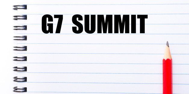 Concept image with words G7 SUMMIT written on notebook page and red pencil on the right