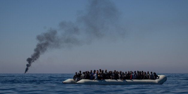 LAMPEDUSA, ITALY - MAY 18: Refugees and migrants wait to be rescued from an overcrowded boat by crew members from the Migrant Offshore Aid Station (MOAS) Phoenix vessel on May 18, 2017 off Lampedusa, Italy. Numbers of refugees and migrants attempting the dangerous central Mediterranean crossing from Libya to Italy has risen since the same time last year with more than 43,000 people recorded so far in 2017. MOAS is a Malta based NGO dedicated to providing professional search-and-rescue assistance to refugees and migrants in distress at sea. Since the start of the year MOAS have rescued and assisted 3214 people and are currently patrolling and running rescue operations in international waters off the coast of Libya. (Photo by Chris McGrath/Getty Images)