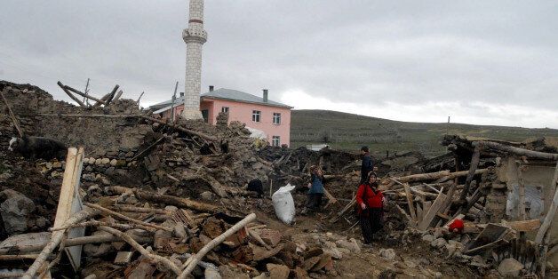 Villagers search among the ruins in Okcular village in the eastern province of Elazig, on March 9, 2010, a day after a strong earthquake, with a preliminary magnitude of 6, hit eastern Turkey. The quake affected villages near the town of Kovancilar, toppling stone or mud-brick homes and minarets of mosques, officials and media reports said. The worst-hit area was the village of Okcular where some 17 people were reported killed and homes crumbled into piles of dirt. AFP PHOTO / STR (Photo credit should read STR/AFP/Getty Images)