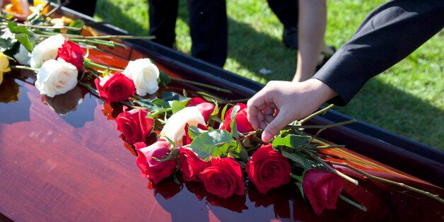 shot of roses and flowers on top of coffin