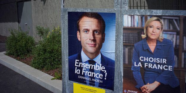 New official posters for the candidates for the 2017 French presidential election, Emmanuel Macron (L), head of the political movement En Marche !, or Onwards !, and Marine Le Pen (R), French National Front (FN) political party leader, are displayed in Fontaines-sur-Saone, near Lyon, France, April 30, 2017. REUTERS/Robert Pratta