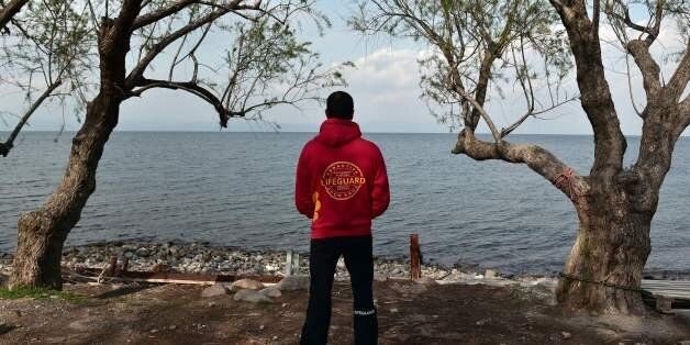 TOPSHOT - A Member of the Proactiva Open Arms rescue team looks at the sea at their base near Skala Sykamiasn on the island of Lesbos on March 15, 2017 almost a year after an EU-Turkey deal.The deal, signed on March 18, 2016, has sought to stem the flow of migrants from Turkey to the EU, in particular Greece, by land and sea routes. While the flows remain slow, rescue teams are still present on the island. / AFP PHOTO / LOUISA GOULIAMAKI (Photo credit should read LOUISA GOULIAMAKI/AFP/Getty Images)