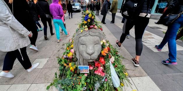 People walk by flowers near Ahlens department store at the pedestrian street Drottninggatan in central Stockholm on April 12, 2017, five days after a hijacked beer truck plowed into pedestrians there killing four people, injuring 15 others. / AFP PHOTO / TT News Agency / Fredrik SANDBERG / Sweden OUT (Photo credit should read FREDRIK SANDBERG/AFP/Getty Images)