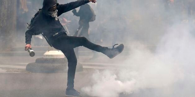 A man kicks back a tear gas canister at police in Paris on April 27, 2017 during a demonstration against the results of the first round of the presidential election. / AFP PHOTO / Lionel BONAVENTURE (Photo credit should read LIONEL BONAVENTURE/AFP/Getty Images)