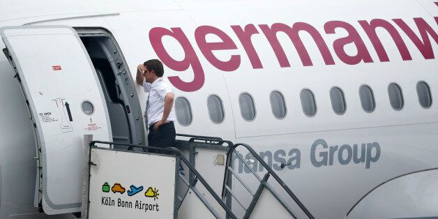 A member of staff leans on a Germanwings plane as he waits to depart following a security alert at Cologne airport, in Cologne, Germany May 30, 2016. REUTERS/Wolfgang Rattay