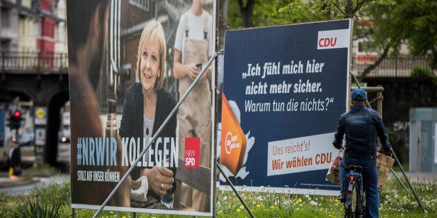 DUESSELDORF, GERMANY - MAY 03: A man rides a bicycle past election campaign billboards of the German Social Democrats (SPD) and the German Christian Democrats (CDU) ahead of state elections in North Rhine-Westphalia on May 3, 2017 in Duesseldorf, Germany. North Rhine-Westphalia is Germany's most populous state and will hold state elections on May 14. According to a recent poll the German Christian Democrats (CDU) and the German Social Democrats (SPD) are in a tight race for the lead while the po