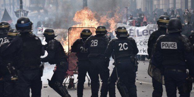 Protesters launch a burning trolley towards French CRS anti-riot police officers during a march for the annual May Day workers' rally in Paris on May 1, 2017. / AFP PHOTO / PHILIPPE LOPEZ (Photo credit should read PHILIPPE LOPEZ/AFP/Getty Images)