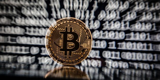 BERLIN, GERMANY - JANUARY 06: In this photo illustration a model Bitcoin stands in front of a binary code on January 06, 2017 in Berlin, Germany. Shooting with slow shutter and zoom during exposure. (Photo Illustration by Thomas Trutschel/Photothek via Getty Images)