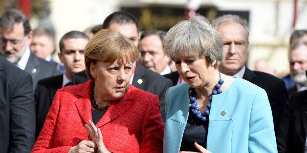 Germany's Chancellor Angela Merkel (L) speaks with British Prime Minister Theresa May on their way for a family picture during an European Union summit on February 3, 2017 in Valletta, Malta. European Union leaders will try to rally together to revive the beleaguered bloc at a special summit in Malta Friday in the face of 'threats' from migration, Brexit and Donald Trump. It is the latest in a series of crisis meetings since Britain voted to leave the EU last June, but fears about the new US president have strengthened the sense that the bloc is now at a decisive moment in its history. / AFP / Matthew Mirabelli / Malta OUT (Photo credit should read MATTHEW MIRABELLI/AFP/Getty Images)
