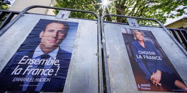 New official posters for the candidates for the 2017 French presidential election, Emmanuel Macron (L), head of the political movement En Marche !, or Onwards !, and Marine Le Pen (R), French National Front (FN) political party leader, are displayed in Caluire, near Lyon, France, April 30, 2017. REUTERS/Robert Pratta