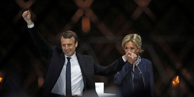 French President elect Emmanuel Macron and his wife Brigitte Trogneux celebrate on the stage at his victory rally near the Louvre in Paris, France May 7, 2017. REUTERS/Christian Hartmann TPX IMAGES OF THE DAY