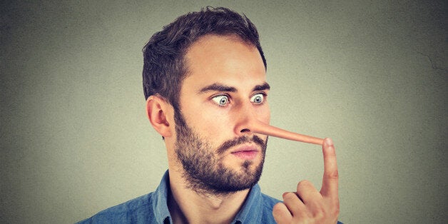 Man with long nose isolated on grey wall background. Liar concept. Human face expressions, emotions, feelings.