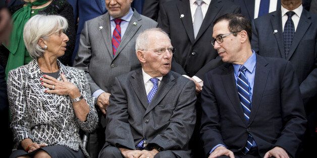 Christine Lagarde, managing director of the International Monetary Fund (IMF), from front left, Wolfgang Schaeuble, Germany's finance minister, and Steven Mnuchin, U.S. Treasury secretary, speak before a group photograph at the spring meetings of the International Monetary Fund (IMF) and World Bank in Washington, D.C., U.S., on Saturday, April 22, 2017. The emergence of protectionist forces could undermine a modest brightening of the global growth outlook and is putting severe strain on the post-World War II economic order, the IMF said this week. Photographer: Pete Marovich/Bloomberg via Getty Images