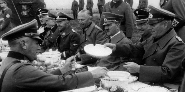 (GERMANY OUT) Hitler, Adolf - Politician, NSDAP, Germany *20.04.1889-30.04.1945+ Adolf Hitler eating in a field kitchen with officers of the German Wehrmacht near Karlsbad, besides Hitler to the right: Konrad Henlein and General Wilhelm Keitel, to the left: General Walter v. Reichenau, Reichsfuehrer SS Heinrich Himmler, General Heinz Guderian; Walther Hewel - 04.10.1938 - Photographer: Presse-Illustrationen Heinrich Hoffmann - Published by: 'Deutschland' 11/1938 Vintage property of ullstein bild (Photo by Heinrich Hoffmann/ullstein bild via Getty Images)