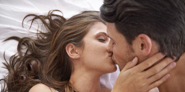 Shot of an affectionate young couple kissing in bed
