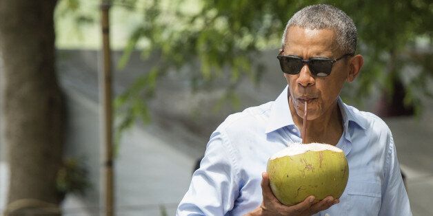 US President Barack Obama drinks from a coconut as he makes a surprise stop for a drink alonside the Mekong River in Luang Prabang on September 7, 2016.Obama became the first US president to visit Laos in office, touching down in Vientiane late on September 5 for a summit of East and South East Asian leaders. / AFP / SAUL LOEB (Photo credit should read SAUL LOEB/AFP/Getty Images)