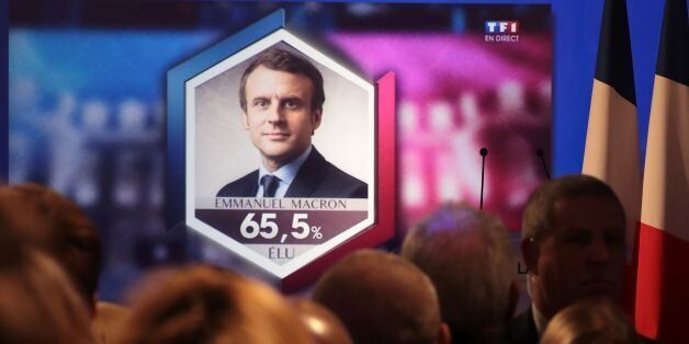Supporters of French presidential election candidate for the far-right Front National (FN) party Marine Le Pen watch a TV screen displaying French President elected Emmanuel Macron with an estimated score of more than 65,5 precent, in Paris, on May 7, 2017, after the second round of the French presidential election. / AFP PHOTO / joel SAGET (Photo credit should read JOEL SAGET/AFP/Getty Images)