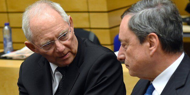 German Finance Minister Wolfgang Schauble (L) speaks with European Central Bank President Mario Draghi during an emergency Eurogroup finance ministers meeting at the European Council in Brussels on February 11, 2015. Proposals by the new government in Athens to renegotiate the terms of its massive international bailout are scheduled to be discussed by eurozone finance ministers in Brussels on February 11 and 12. AFP PHOTO / EMMANUEL DUNAND (Photo credit should read EMMANUEL DUNAND/AFP/Getty Images)