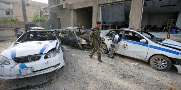 A member of Iraqi security forces walks near the site of a suicide car bomb attack in Baghdad, Iraq April 29, 2017. REUTERS/Khalid al Mousily