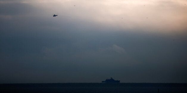 A helicopter flies next to a ship near the crash site of a Russian military Tu-154 plane, which crashed into the Black Sea on its way to Syria on Sunday, in the Black Sea resort city of Sochi, Russia, December 26, 2016. REUTERS/Maxim Shemetov