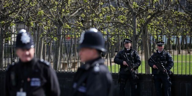 Armed British police officers (R) hold their weapons as they stand on duty outside the Houses of Parliament in Westminster, central London on April 11, 2017. / AFP PHOTO / Daniel LEAL-OLIVAS (Photo credit should read DANIEL LEAL-OLIVAS/AFP/Getty Images)