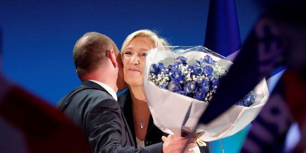 Mayor of Henin-Beaumont Steeve Briois gives a bouquet of flowers to Marine Le Pen, French National Front (FN) political party leader and candidate for French 2017 presidential election, as she celebrates after early results in the first round of 2017 French presidential election, in Henin-Beaumont, France, April 23, 2017. REUTERS/Charles Platiau