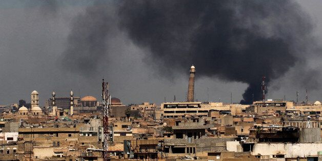 Smoke billows from behind the Great Mosque of al-Nuri in Mosul's Old City on April 17, 2017, during an offensive by Iraqi security forces to recapture the city from Islamic State (IS) group fighters. / AFP PHOTO / AHMAD AL-RUBAYE (Photo credit should read AHMAD AL-RUBAYE/AFP/Getty Images)