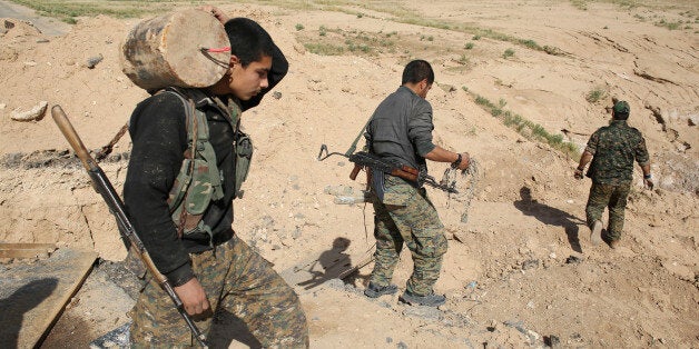 A member of the Sinjar Resistance Units (YBS), a militia affiliated with the Kurdistan Workers' Party (PKK), carries a disarmed improvised explosive device which was placed by Islamic State fighters near the village of Umm al-Dhiban, northern Iraq, April 30, 2016. They share little more than an enemy and struggle to communicate on the battlefield, but together two relatively obscure groups have opened up a new front against Islamic State militants in a remote corner of Iraq. The unlikely allianc