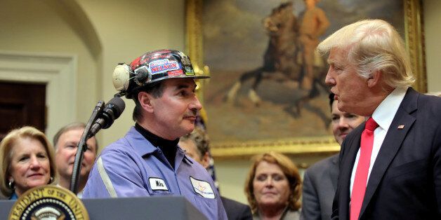 Michael Nelson, a coal miner worker shakes hands with U.S. President Donald Trump as he prepares to sign Resolution 38, which nullfies the
