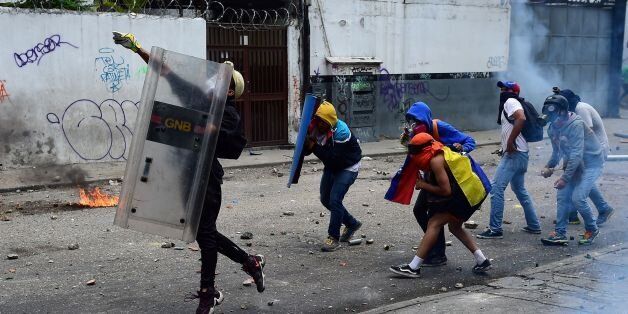 Demonstrators clash with the police during a rally against Venezuelan President Nicolas Maduro, in Caracas on April 19, 2017.Venezuela braced for rival demonstrations Wednesday for and against President Nicolas Maduro, whose push to tighten his grip on power has triggered waves of deadly unrest that have escalated the country's political and economic crisis. / AFP PHOTO / Ronaldo SCHEMIDT (Photo credit should read RONALDO SCHEMIDT/AFP/Getty Images)