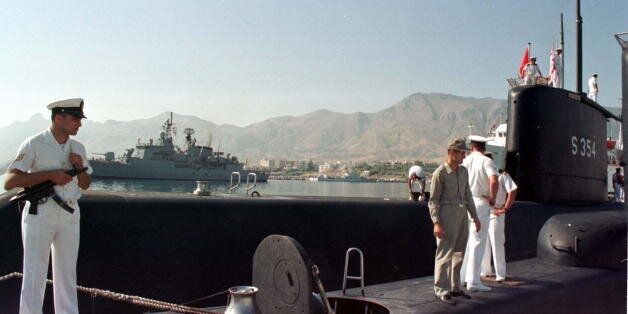 Turkish sailors aboard a submarine anchored off Kyrenia port July 18 after a fleet of six Turkish navy vessels arrived to northern Cyprus July 18. In the background is Turkish frigate TCG Barbaros anchors off the port. Two submarines, two frigates, and two gunboats arrived in Kyrenia port in northern Cyprus for the 23rd anniversary celebrations of Turkey's 1974 invasion of Cyprus.CYPRUS TURKEY