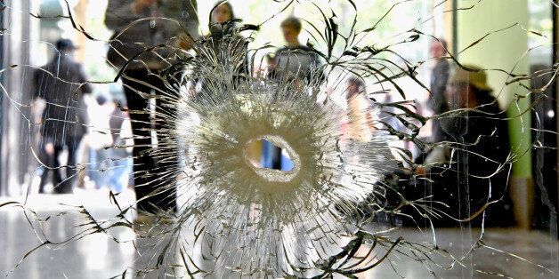 PARIS, FRANCE - APRIL 21: People look at a bullet hole in a window near to the Marks and Spencer on the Champs Elysees in Paris following yesterday's shooting of a police officer on April 21 2017. One police officer was killed and another wounded in a shooting on Paris's Champs Elysees, police said just days ahead of France's presidential election. France's interior ministry said the attacker was killed in the incident on the world famous boulevard that is popular with tourists. (Photo by Jeff J Mitchell/Getty Images)