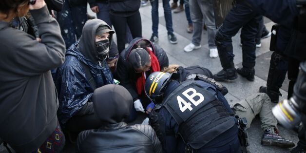 French anti-riot police forces tend to a demonstrator lying on the ground in Paris on April 23, 2017 following the announcement of the results of the first round of the Presidential election.Centrist Emmanuel Macron finished ahead of far-right leader Marine Le Pen on Sunday to qualify alongside her for the runoff in France's presidential election, initial projections suggested. / AFP PHOTO / Benjamin CREMEL (Photo credit should read BENJAMIN CREMEL/AFP/Getty Images