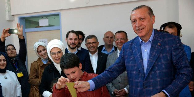Turkish President Tayyip Erdogan (R) with his wife Emine casts his ballot at a polling station during a referendum in Istanbul, Turkey, April 16, 2017. REUTERS/Murad Sezer