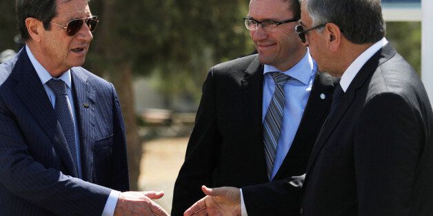 Greek Cypriot leader and Cyprus President Nicos Anastasiades (L) shake hands with Turkish Cypriot leader Mustafa Akinci (R), as UN envoy Espen Barth Eide looks on, in the buffer zone of Nicosia airport, Cyprus September 14, 2016. REUTERS/Yiannis Kourtoglou