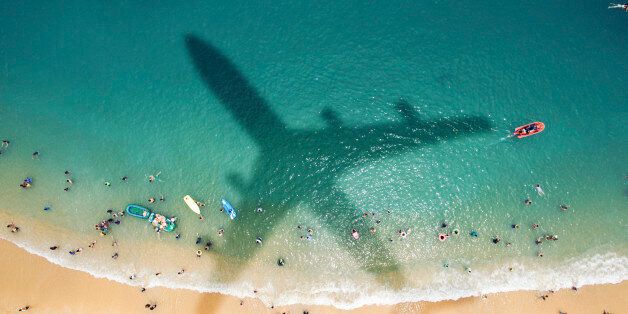 Airplane's shadow over a crowded beach