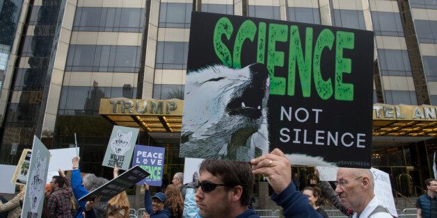 People with signs walk past the Trump International Hotel and Tower during the March for Science on April 22, 2017 in New York.Thousands of people joined a global March for Science on Saturday with Washington the epicenter of a movement to fight back against what many see as an 'assault on facts' by populist politicians. / AFP PHOTO / Bryan R. Smith (Photo credit should read BRYAN R. SMITH/AFP/Getty Images)