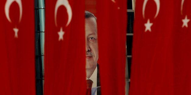 A picture of Turkish President Tayyip Erdogan is seen through Turkish national flags ahead of the constitutional referendum in Istanbul, Turkey, April 14, 2017. REUTERS/Alkis Konstantinidis