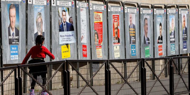 PARIS, FRANCE - APRIL 19: A child walks past official campaign posters for all eleven candidates for the 2017 French presidential elections who runs in the 2017 French presidential election, is seen on April 19, 2017 in Paris, France. French 2017 presidential election which will take place on April 23 and May 07, 2017. (Photo by Chesnot/Getty Images)