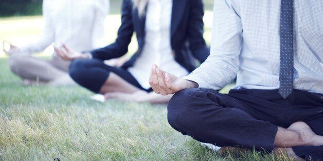 Business people practicing yoga in park